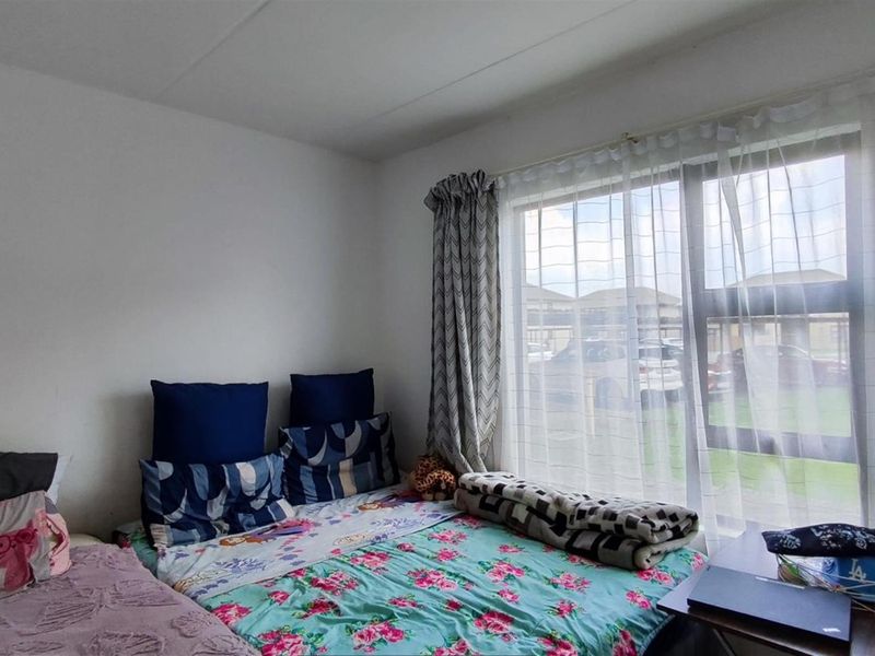 A functional bedroom featuring a large window that allows for natural light, providing a bright and airy atmosphere.