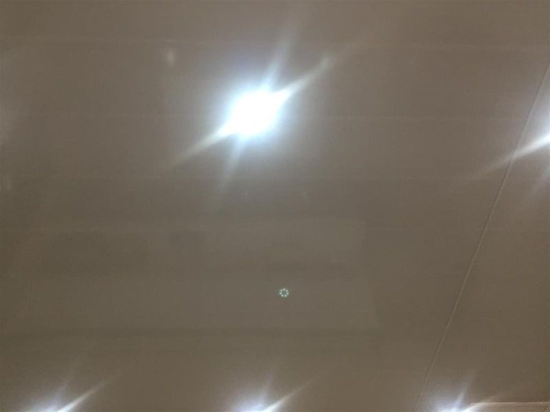 A low-quality, poorly framed image showing only a ceiling with recessed lighting fixtures.
