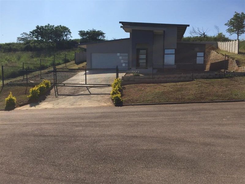Modern single-story house featuring a contemporary facade, single garage, concrete driveway, and secure perimeter fencing.