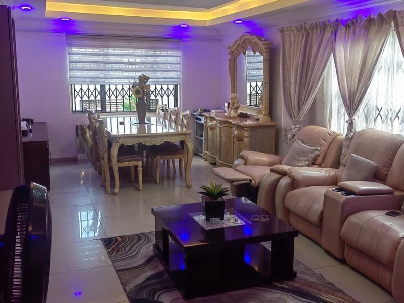 Spacious open-plan living and dining area featuring a modern recessed ceiling with integrated LED lighting and polished tiled flooring.