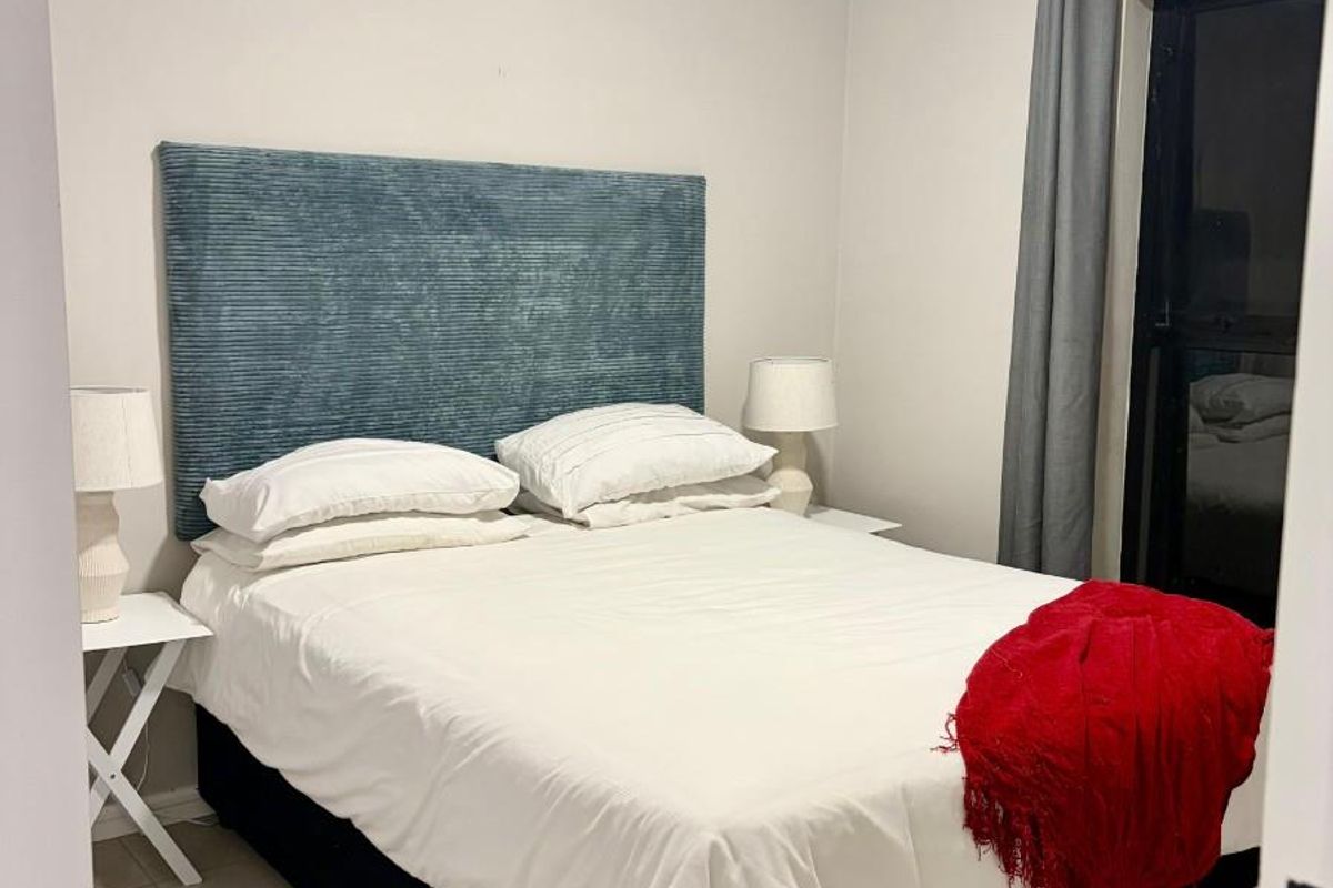 A bedroom featuring tiled flooring and a sliding door providing access to an outdoor area.