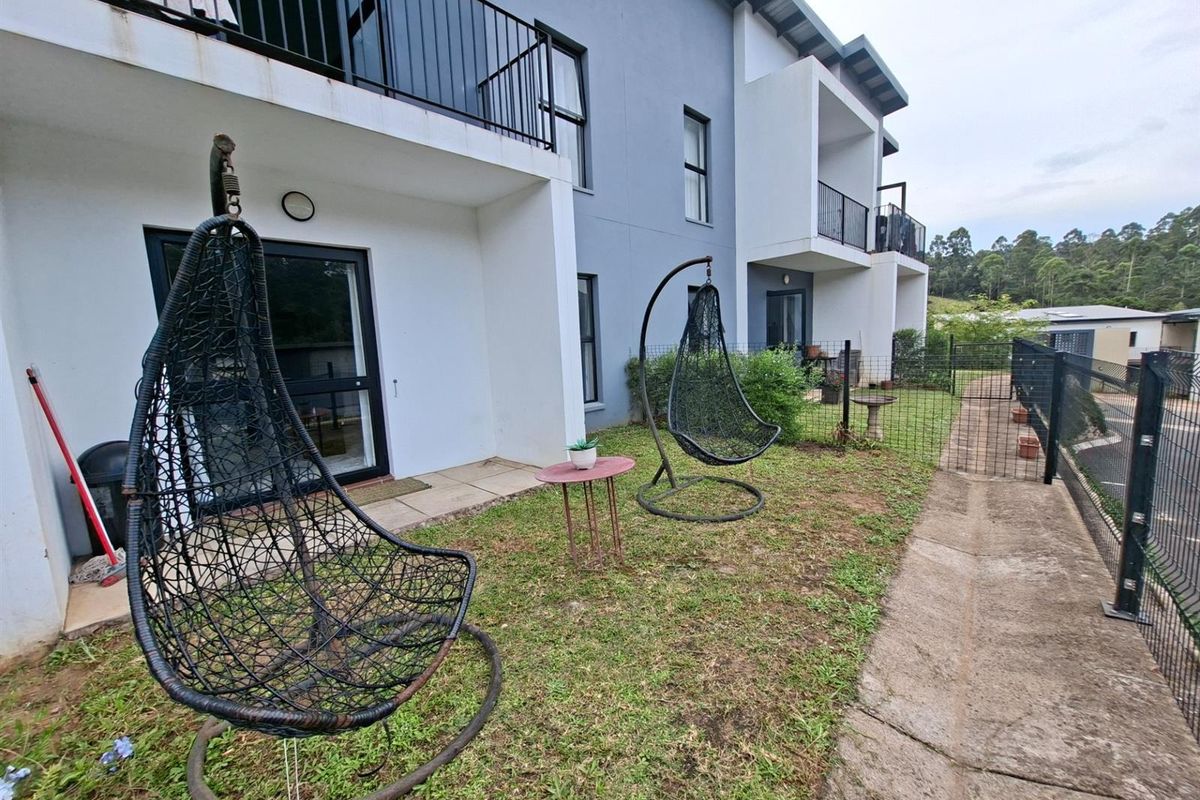 Ground floor apartment exterior featuring a private garden area, paved patio section, and direct access to the living space via sliding glass doors.