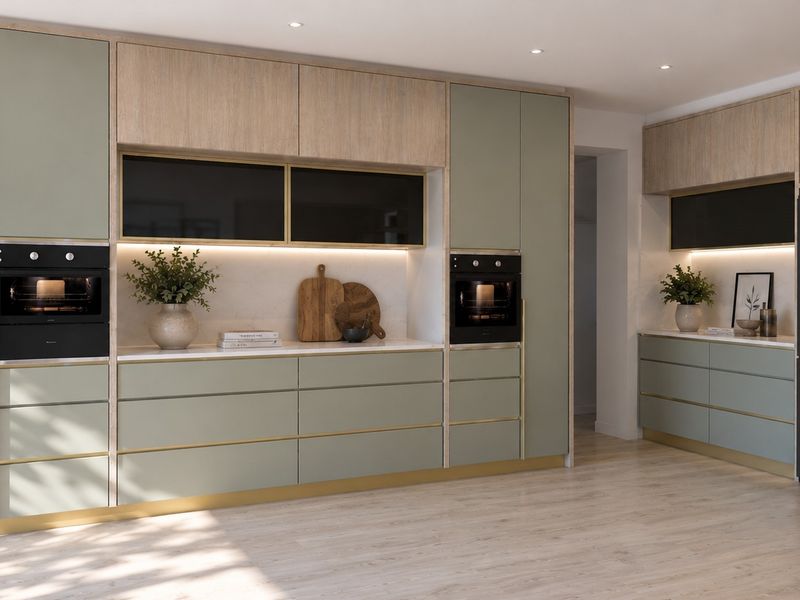 Modern kitchen featuring sage green and wood-tone cabinetry, integrated ovens, stone countertops, and sleek gold-toned hardware accents.