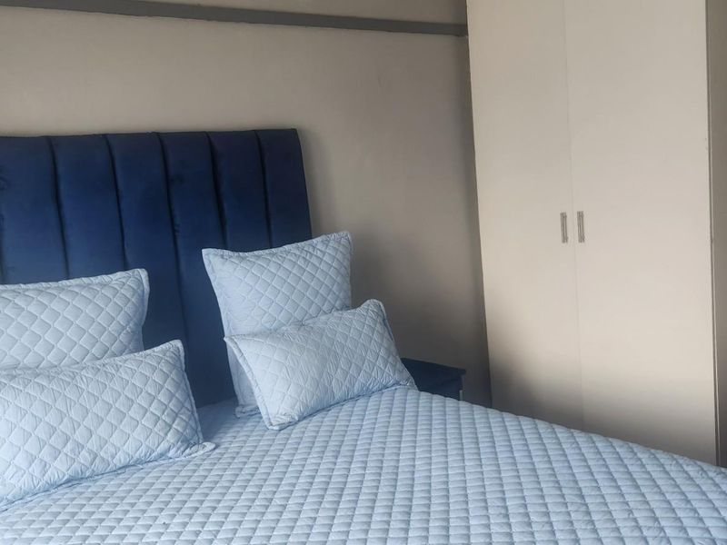 A bedroom featuring a built-in wardrobe and neutral wall finishes.