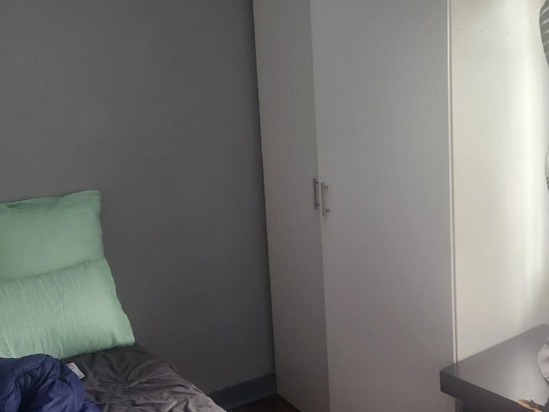 A bedroom featuring a built-in wardrobe and neutral wall finishes, offering a functional space for rest.