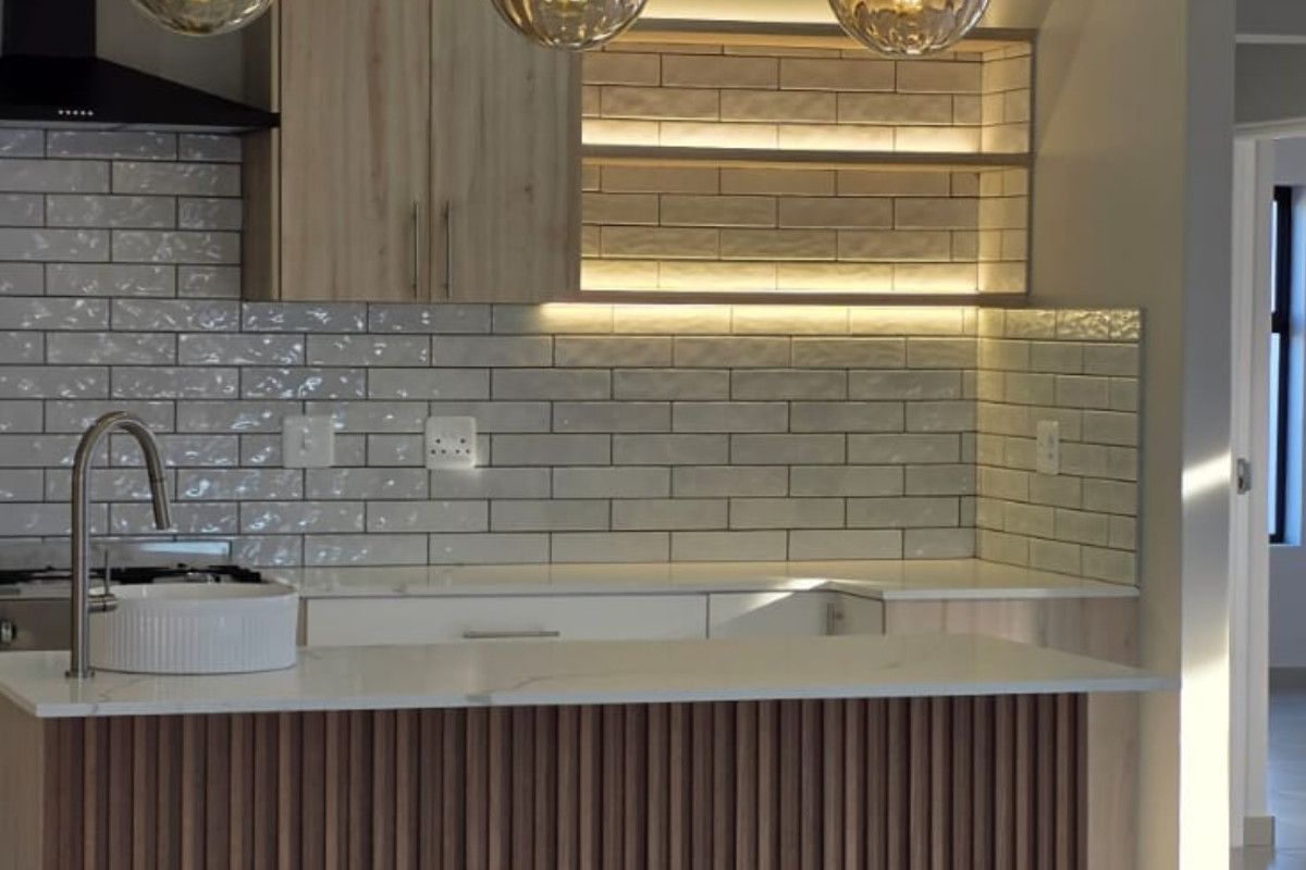 Modern kitchen featuring a slatted wood island, quartz countertops, subway tile backsplash, and elegant pendant lighting with integrated under-cabinet shelving.