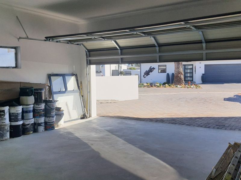 A spacious, functional garage featuring a concrete floor and a sectional overhead door, providing ample storage space and direct access to the driveway.
