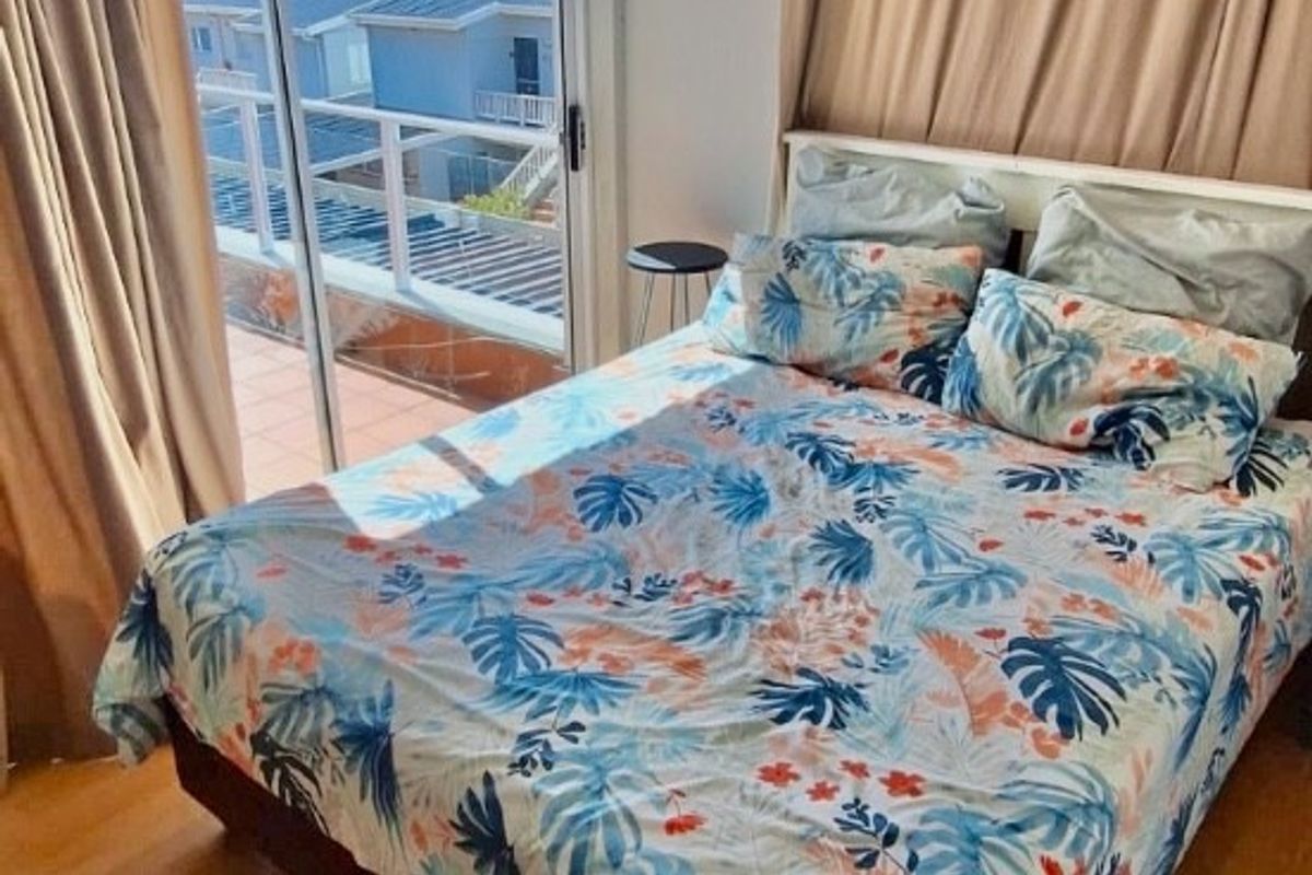 Bedroom featuring laminate flooring and a sliding glass door providing direct access to a balcony with scenic views.