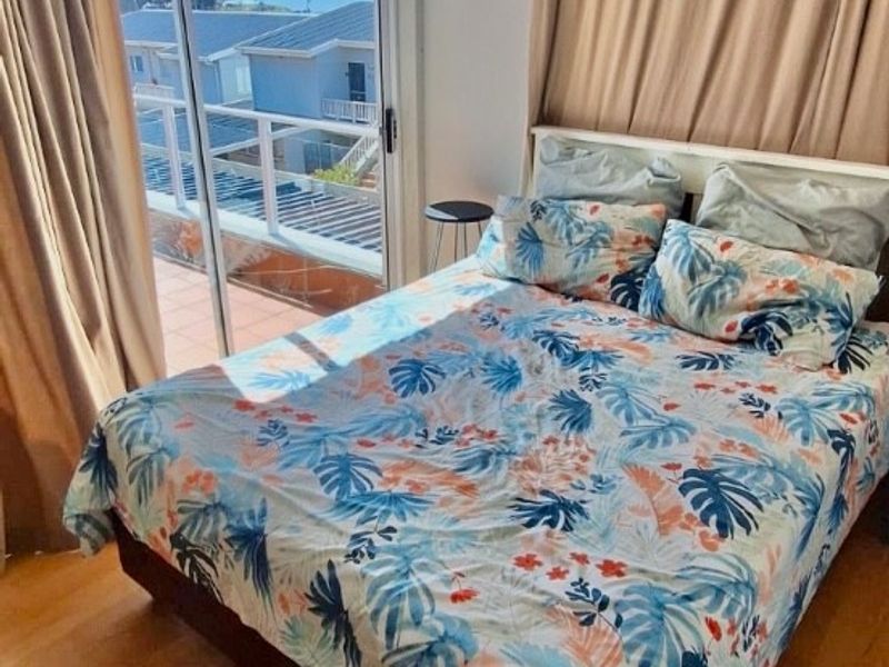 Bedroom featuring laminate flooring and a sliding glass door providing direct access to a balcony with scenic views.
