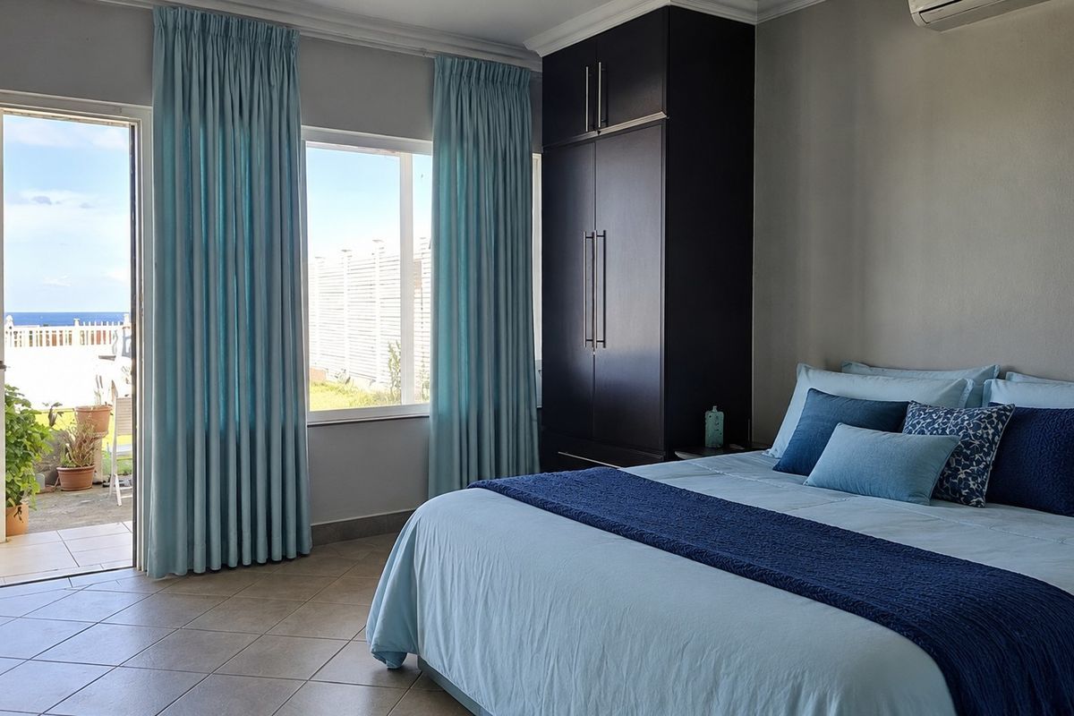 A well-maintained bedroom featuring built-in dark cabinetry, tiled flooring, and direct access to an outdoor patio area.