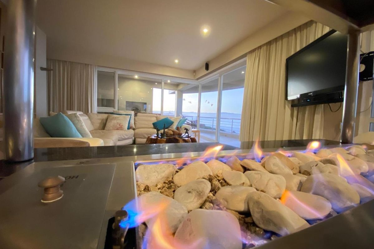 Spacious living room featuring a modern gas fireplace, large sliding glass doors leading to a balcony, and integrated wall-mounted television.