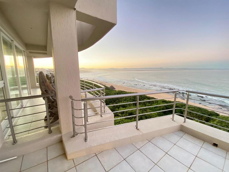 Spacious balcony featuring a stainless steel balustrade and tiled flooring, offering panoramic ocean and coastal views.