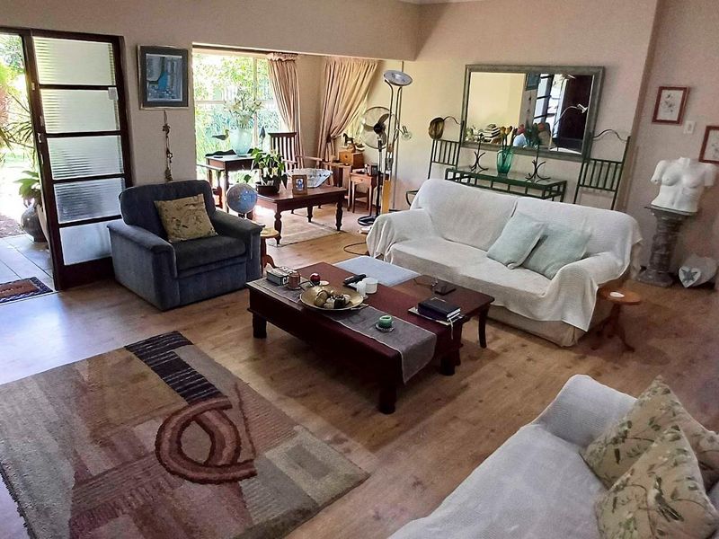 Spacious living room featuring laminate flooring and large sliding glass doors that provide direct access to the outdoor patio area.