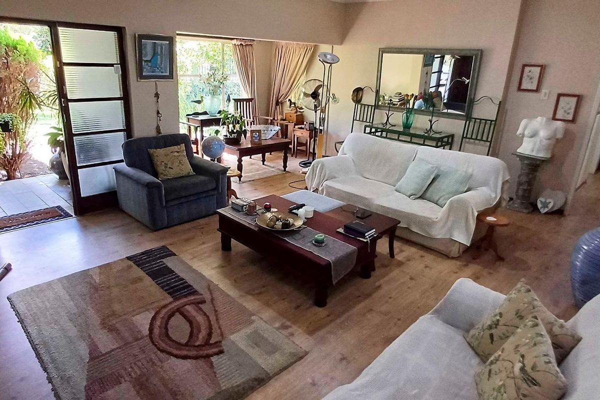 Spacious living room featuring laminate flooring and large sliding glass doors that provide direct access to the outdoor patio area.