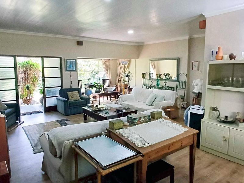 Spacious living room featuring laminate flooring, built-in cabinetry, and sliding glass doors providing direct access to the outdoor patio area.