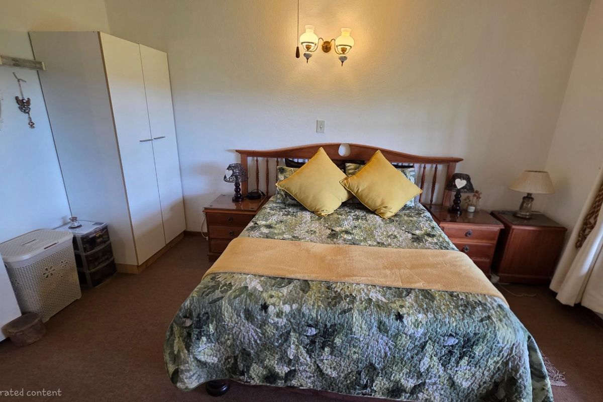 A bedroom featuring a built-in wardrobe, carpeted flooring, and wall-mounted lighting.