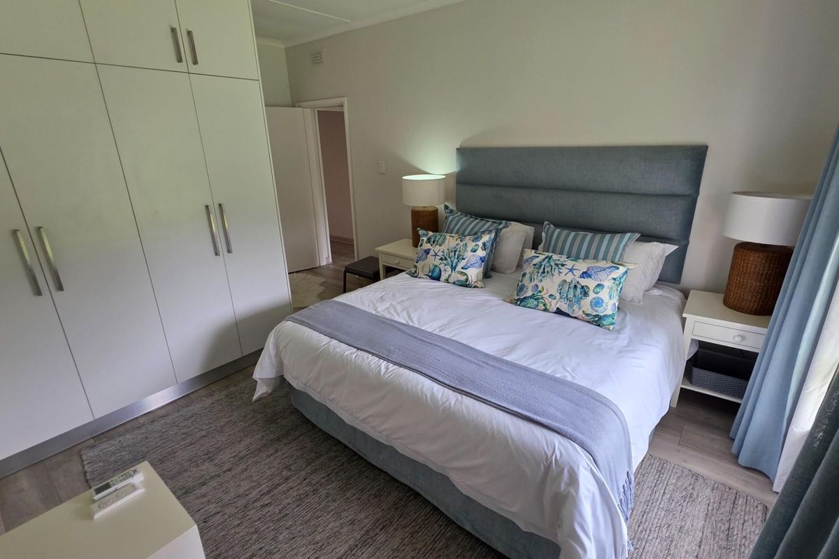 A well-maintained bedroom featuring built-in floor-to-ceiling wardrobes and light-toned flooring, offering a clean and functional living space.
