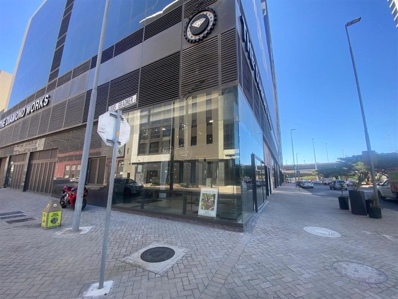 Modern commercial building corner unit with extensive glass frontage, located at a prominent street intersection with high visibility.
