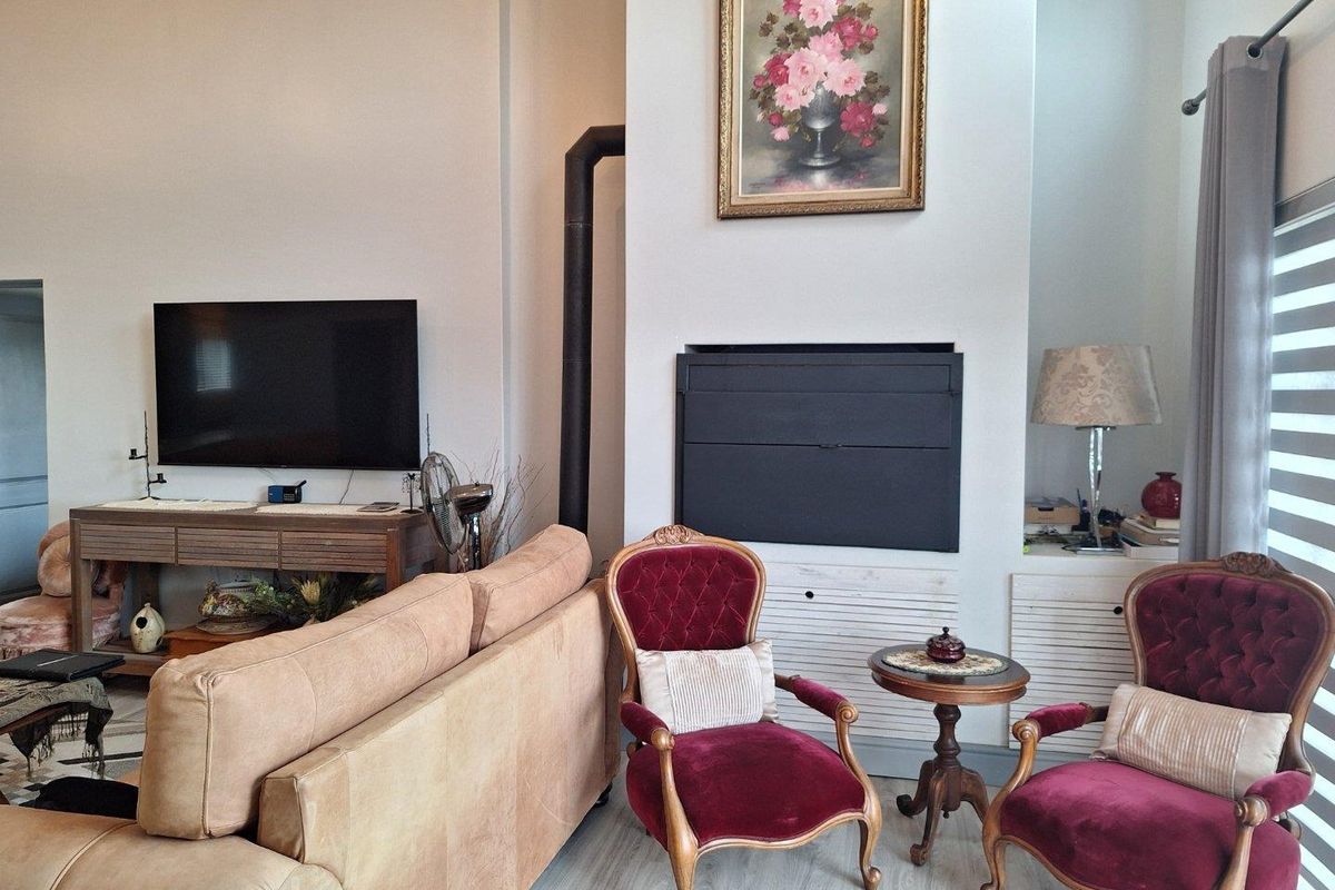 A spacious living room featuring a built-in fireplace with a flue, high ceilings, and light-toned flooring, creating a comfortable and inviting atmosphere.