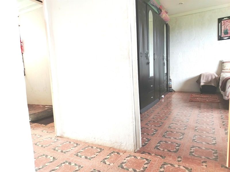 A bedroom featuring tiled flooring and a large built-in wardrobe with mirrored panels.
