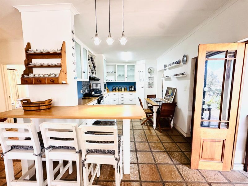 A functional kitchen featuring built-in cabinetry, a breakfast bar, and stone tile flooring, offering a warm and practical space for cooking and dining.