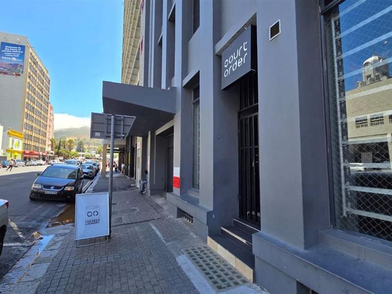 Street-level view of the retail property facade featuring modern grey exterior paint, signage, and a secure entrance.