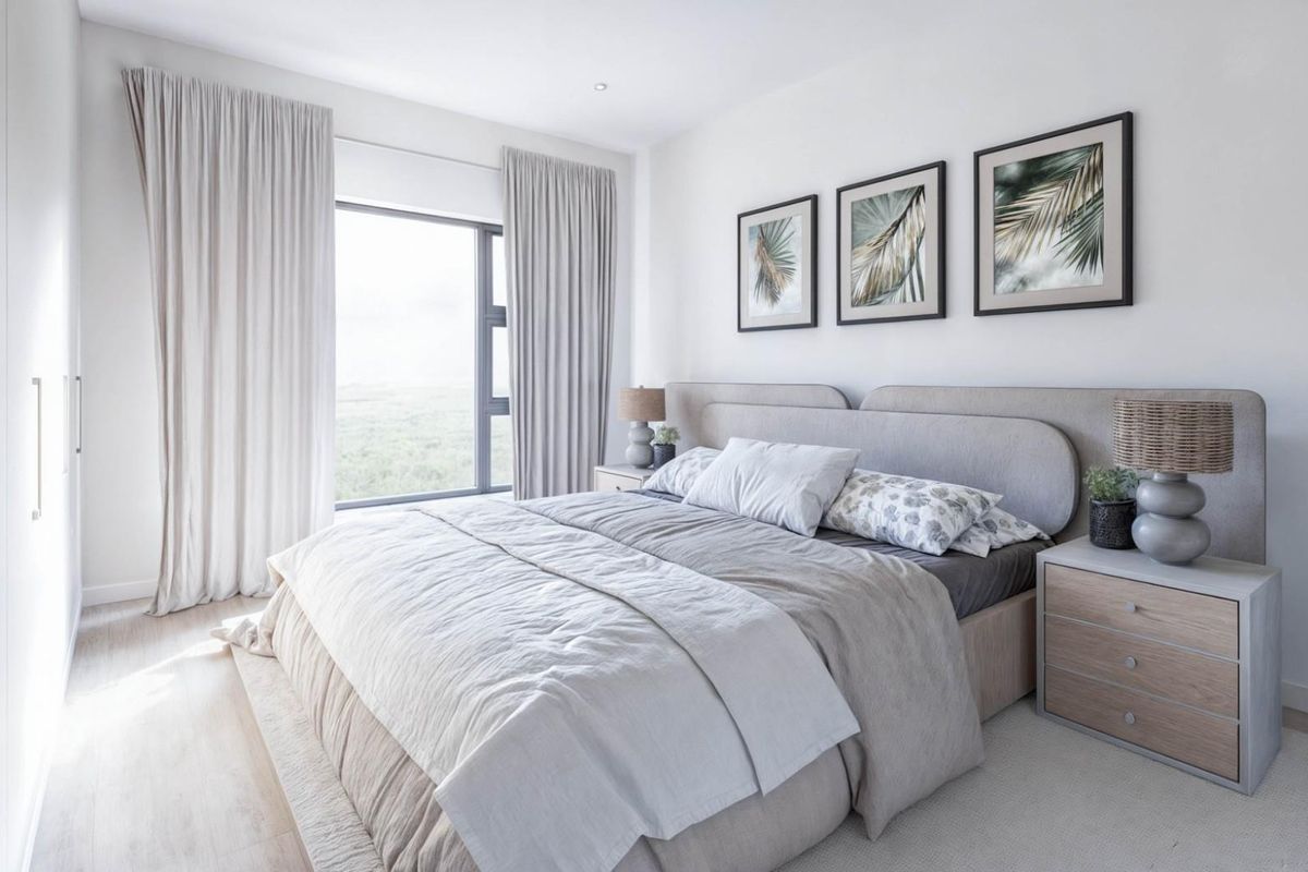 A bright and modern bedroom featuring built-in wardrobes, neutral finishes, and large windows that provide natural light and scenic views.