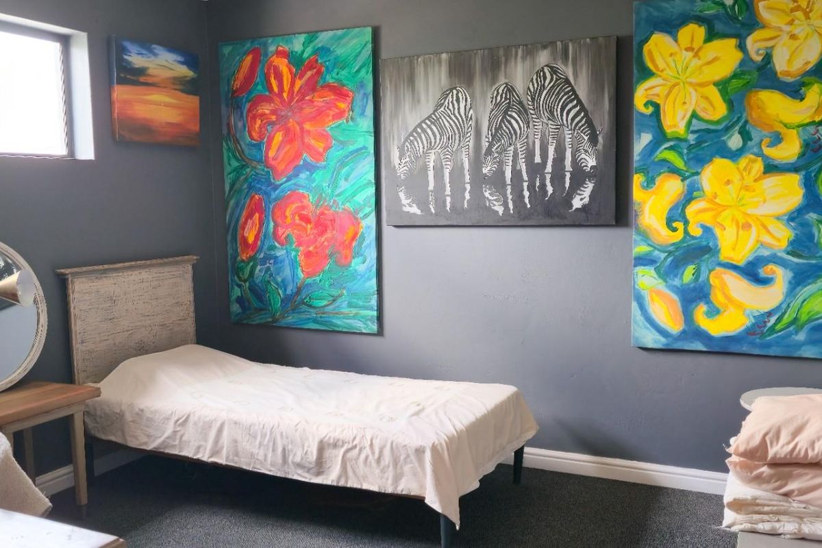A bedroom featuring dark grey walls, carpeted flooring, and a high-set window, providing a neutral base for personalization.