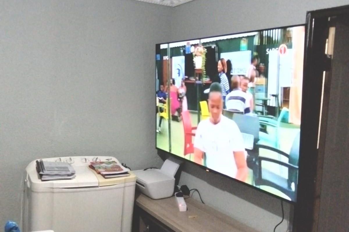 A living room space featuring decorative ceiling cornicing and a wall-mounted television.