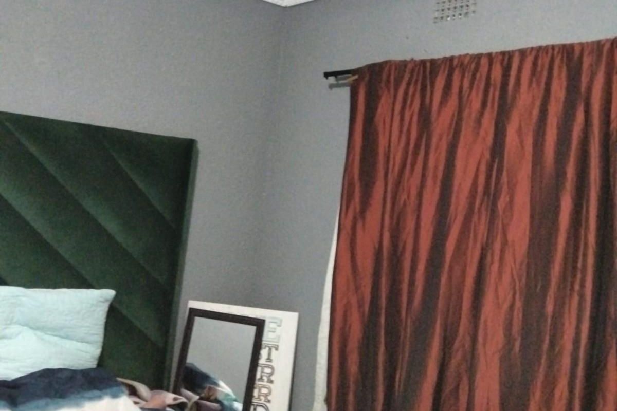 A bedroom featuring grey walls and decorative ceiling cornicing, providing a neutral base for interior design updates.