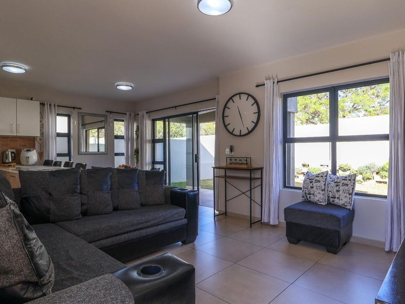 Spacious open-plan living area featuring tiled floors, modern kitchen cabinetry, and large sliding doors providing seamless access to the outdoor space.