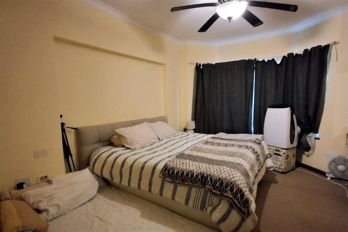 A bedroom featuring a ceiling fan, carpeted flooring, and a window with curtains.