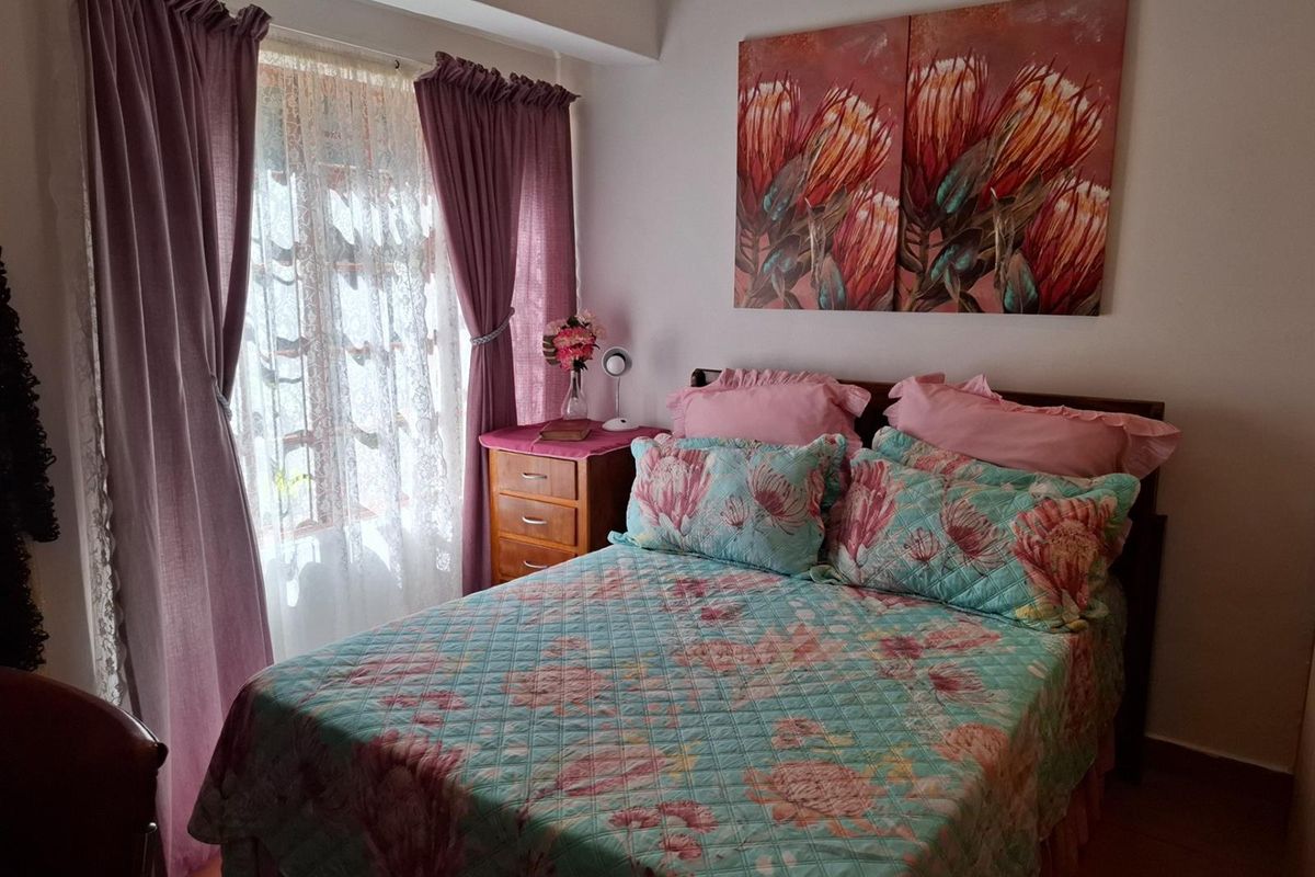 A cozy bedroom featuring tiled flooring and a window with curtain treatments, providing a comfortable and functional sleeping space.