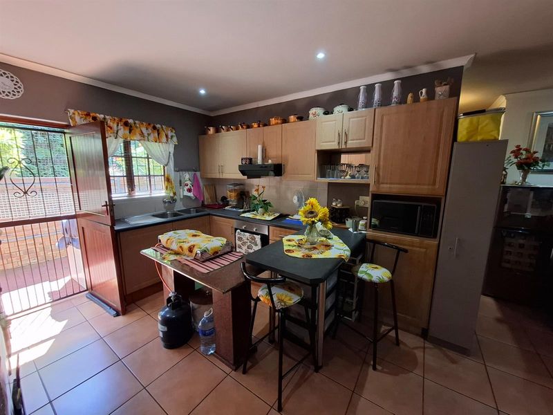 Functional kitchen featuring wooden cabinetry, built-in oven, extractor fan, and a breakfast nook, with direct access to the exterior via a stable door.