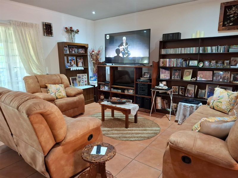 A comfortable living room featuring tiled flooring and recessed ceiling lighting, providing a functional space for relaxation and entertainment.