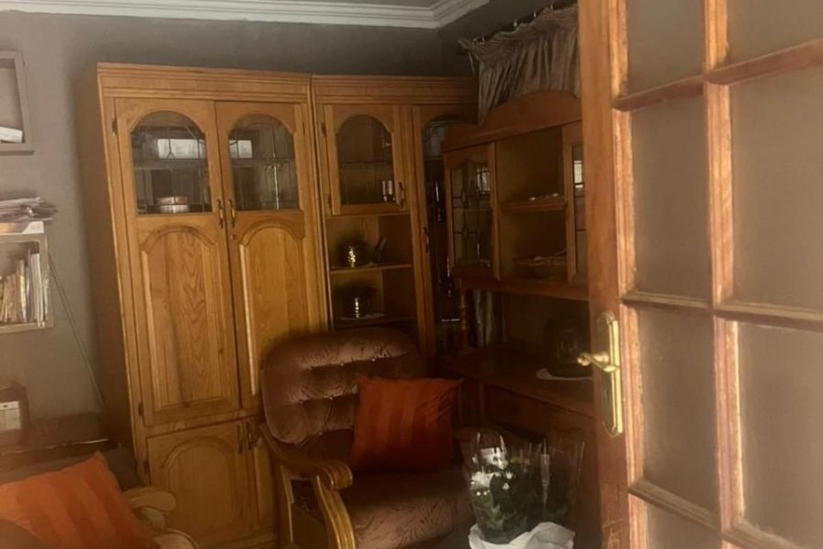 A cozy living room featuring tiled flooring and a classic wooden door frame, providing a warm and traditional atmosphere.