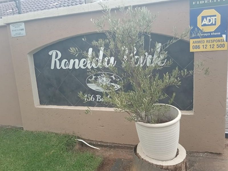 The entrance signage wall for Ronelda Park apartment complex featuring security signage and boundary wall infrastructure.