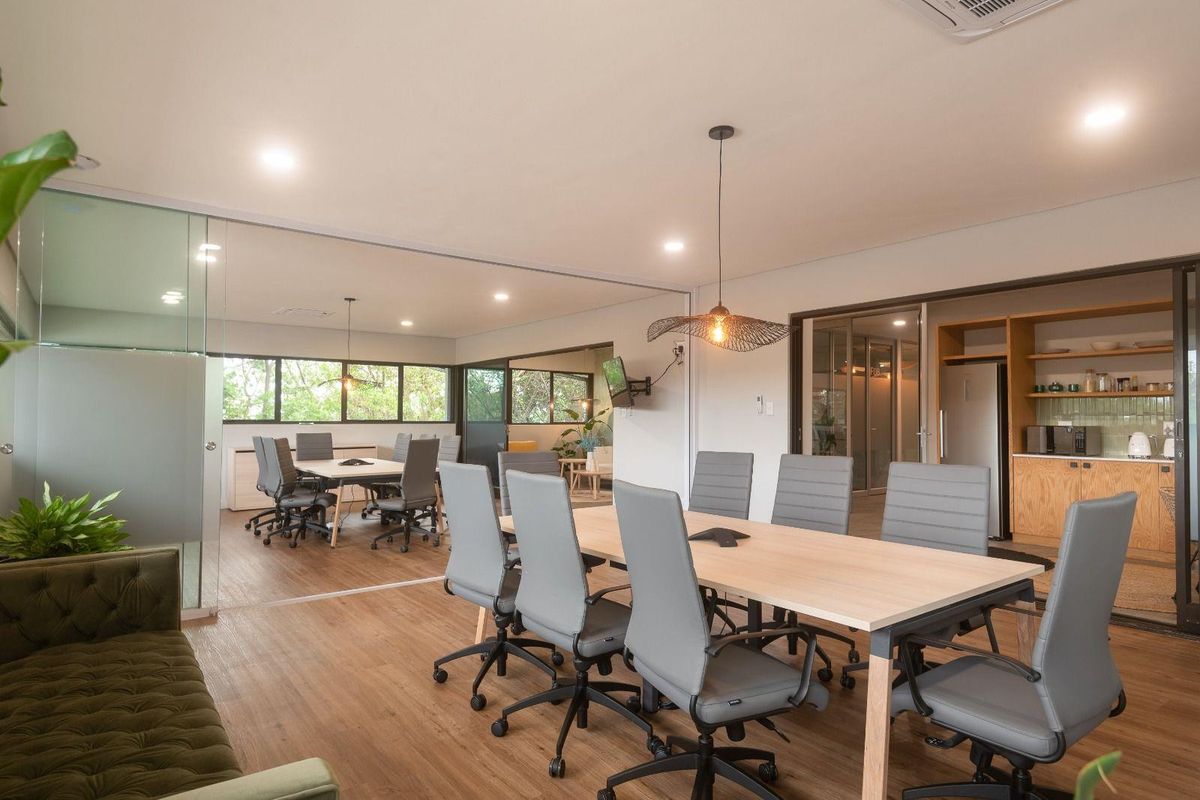 Modern commercial office space featuring glass partitions, open-plan layout, integrated kitchenette, and high-quality finishes throughout.