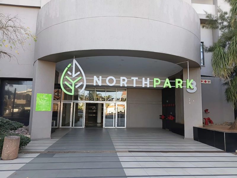 The main entrance of North Park building featuring a covered walkway, glass doors, and prominent building signage.