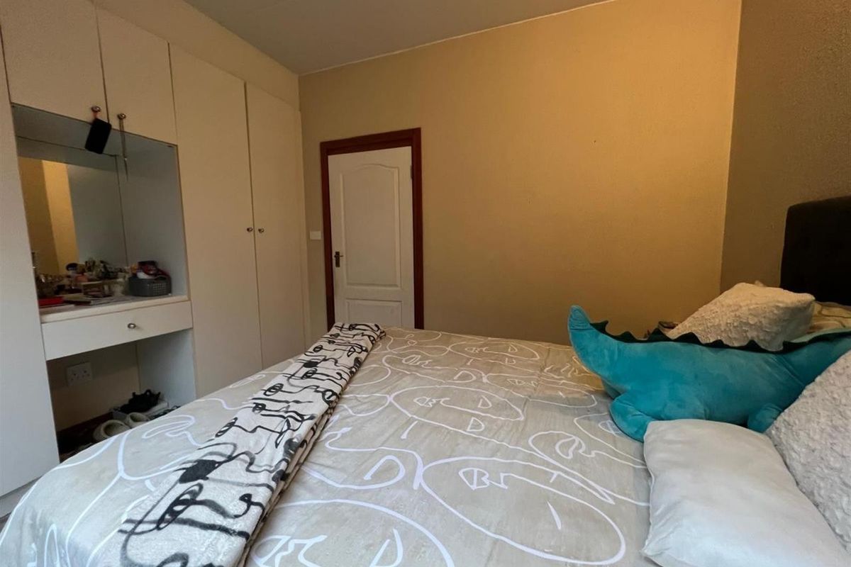 A bedroom featuring built-in wardrobes and an integrated vanity unit, providing functional storage and dressing space.