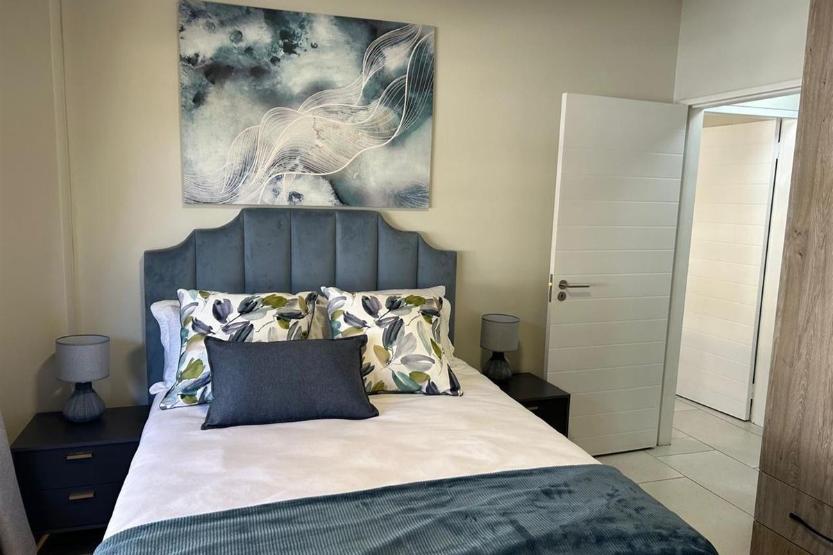 A well-maintained bedroom featuring tiled flooring, a built-in wardrobe, and a neutral color palette.