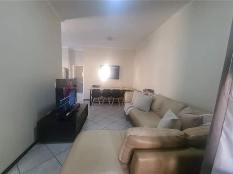 Open-plan living and dining area featuring tiled flooring and neutral wall finishes, providing a functional space for daily living.