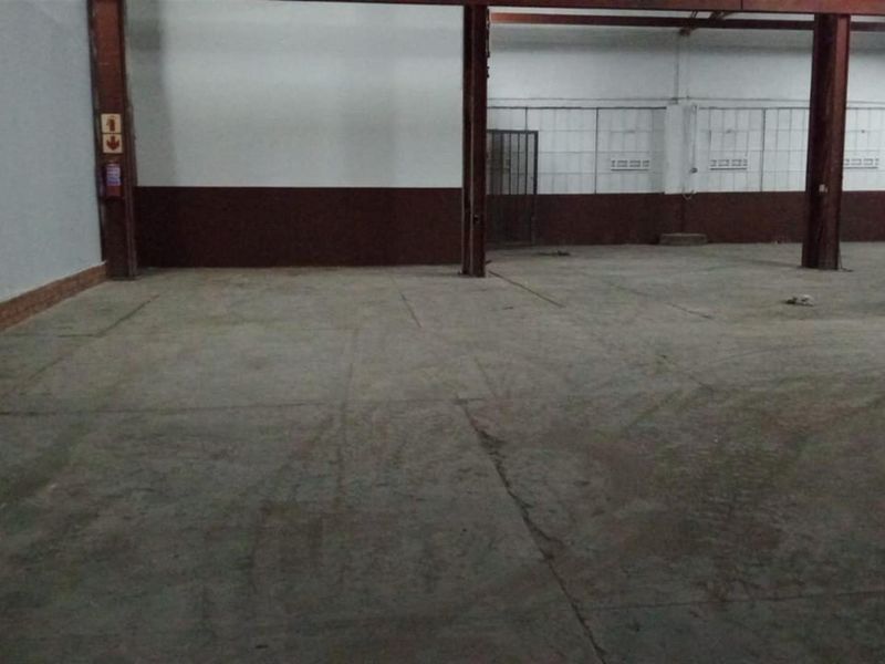 A large, open-plan commercial utility or warehouse space featuring concrete flooring and exposed steel support columns.