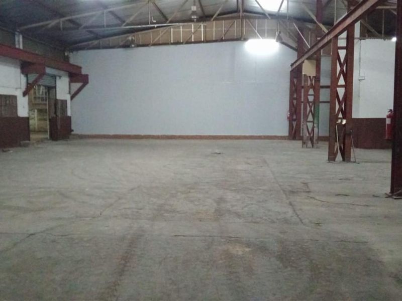 A large, open-plan industrial utility space featuring exposed steel structural beams, concrete flooring, and high ceilings, suitable for warehouse or workshop use.