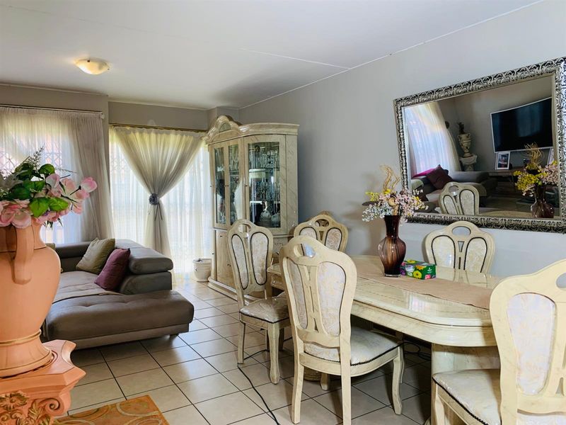 Open plan living and dining area featuring neutral wall tones and ceramic floor tiling, providing a functional space for daily living and entertaining.
