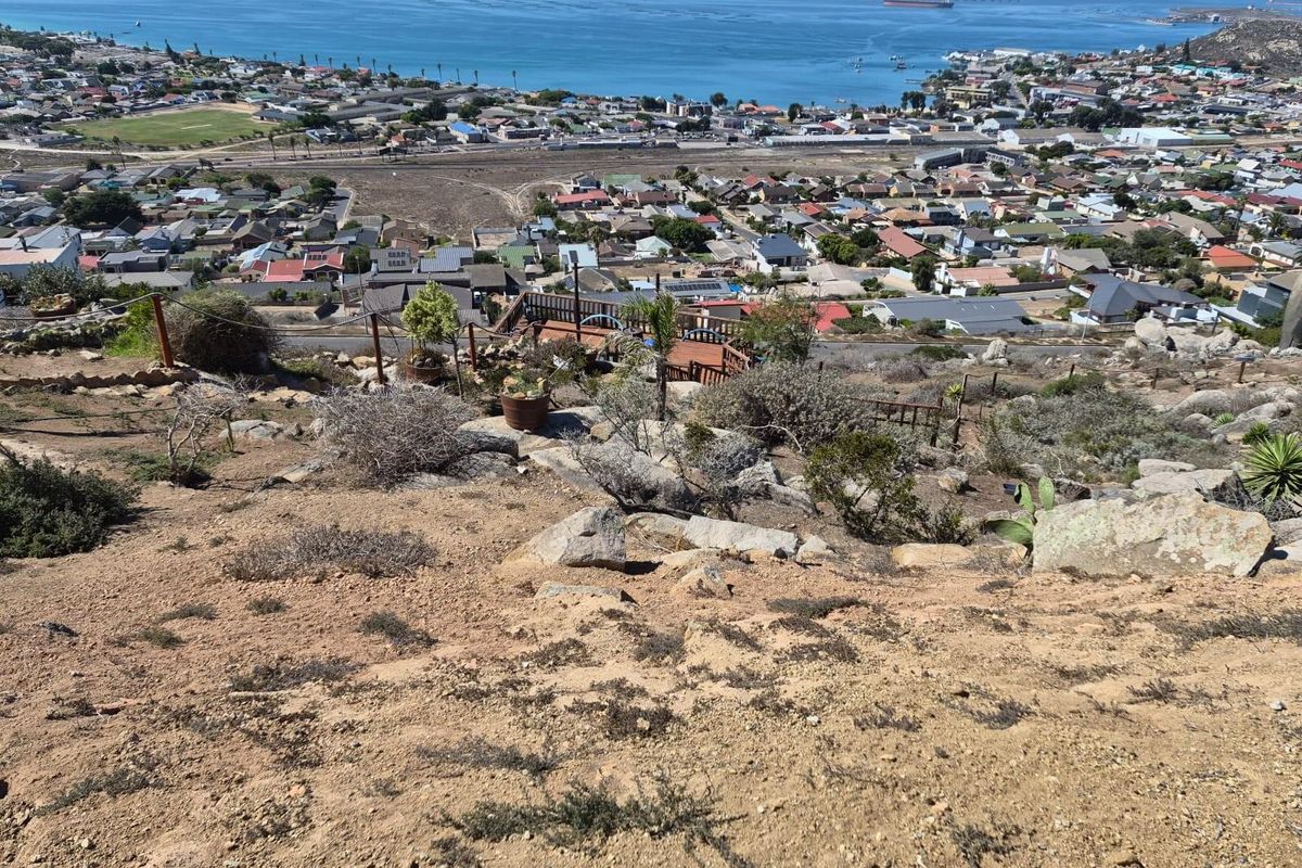 Elevated view overlooking the coastal town, bay, and surrounding landscape from the vacant residential property.