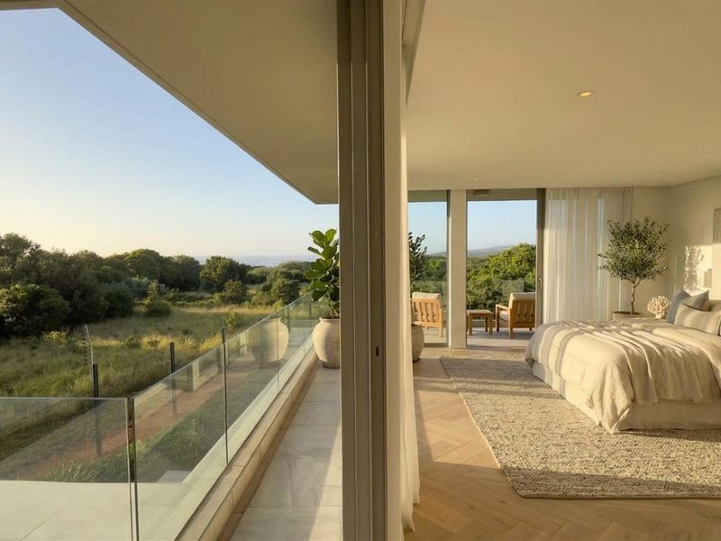 Spacious bedroom featuring herringbone timber flooring and large sliding glass doors opening onto a private balcony with scenic landscape views.