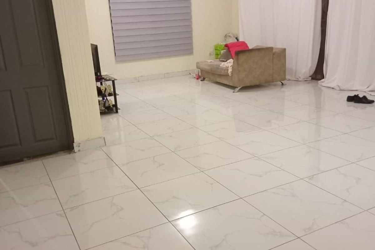 Spacious living area featuring modern marble-look porcelain floor tiles, neutral wall finishes, and large windows with roller blinds and curtain tracks.