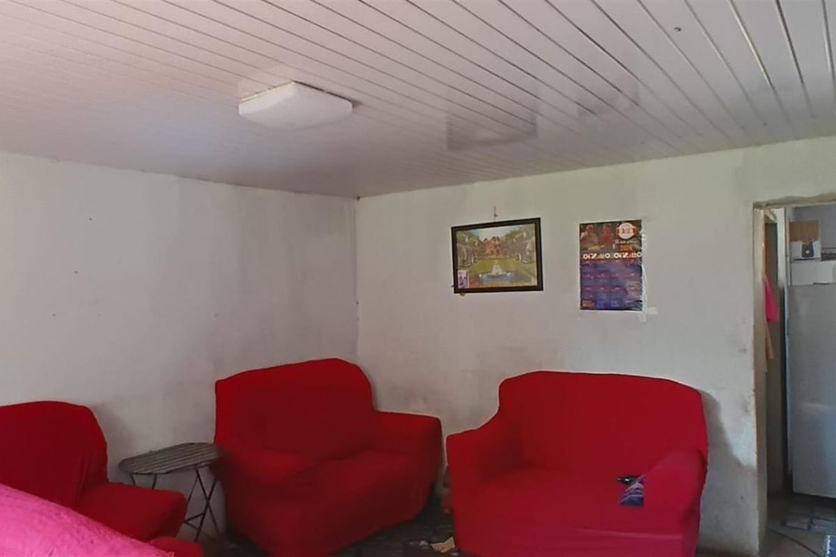 A living room featuring white walls and a white PVC panelled ceiling, providing a basic foundation for potential interior updates.