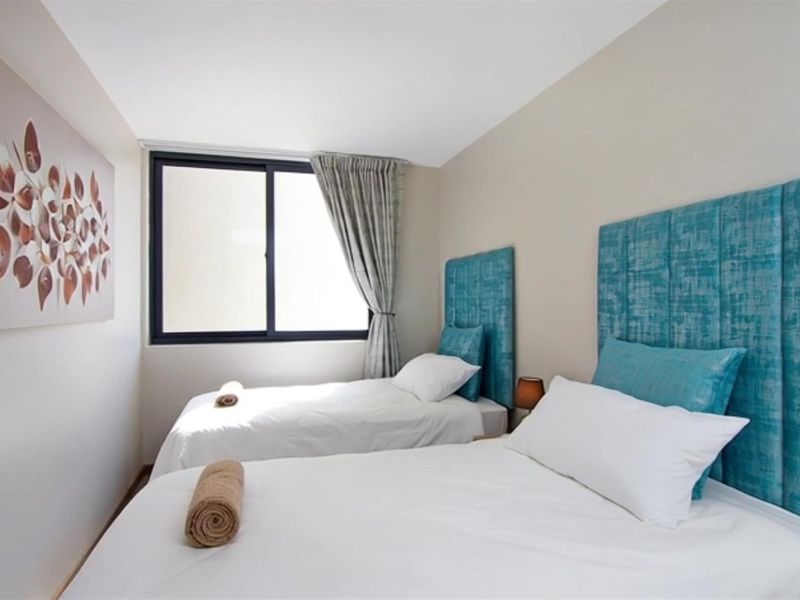 A well-maintained bedroom featuring a sliding window and neutral wall finishes, providing a clean and functional sleeping space.